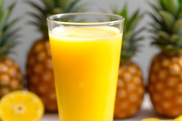 Yellow pineapple smoothie, in a glass there is mist and pineapple