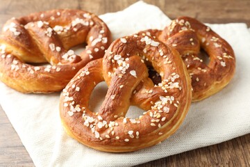 Tasty pretzels with salt on wooden table, closeup