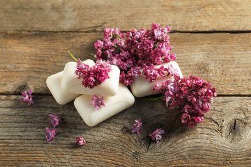 Soap bars and lilac flowers on wooden table