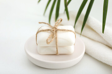 Soap bars and towels on white table, closeup