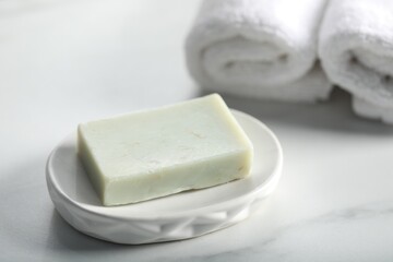 Soap bar and towels on white marble table, closeup
