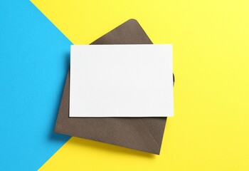 Blank invitation card and envelope on color background, top view. Space for design