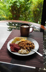 Gallo pinto, a typical Costa Rican dish with rice, red beans, sausage, cream, and a fried egg, and a glass of coffee.