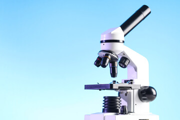 Modern microscope on blue background