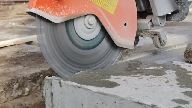 Worker cutting concrete slab with circular saw