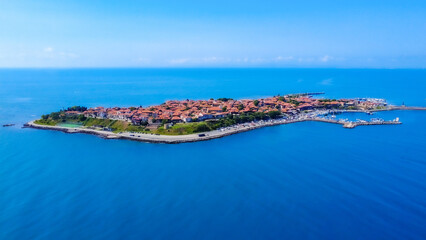 Panoramic aerial view of Old Nesebar on the Bulgarian Black Sea coast. Ancient churches and wooden houses appear over a rocky peninsula, reflecting over 3,000 years of layered Thracian, Greek and Byza