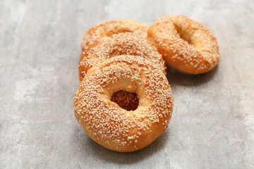 Tasty bagels with sesame seeds on grey background