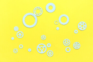 Blue paper gears on yellow background