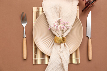 Beautiful table setting with gypsophila flowers on brown background