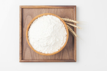 Flour is a powder made by grinding wheat.
