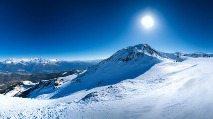 Panoramic View Of Snowy Mountain Range Under Sunny Blue Sky