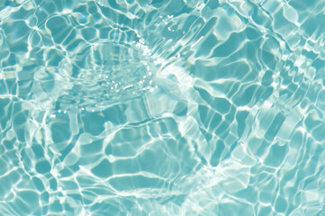 Blue water with ripples on the surface. Defocus blurred transparent blue colored clear calm water surface texture with splashes and bubbles. Water waves with shining pattern texture background.