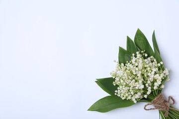 Beautiful lily-of-the-valley flowers on white background, top view. Space for text