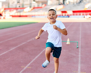 Fototapeta premium Young children having athletic exercise class running on the track, healthy lifestyle and children sport education concepts