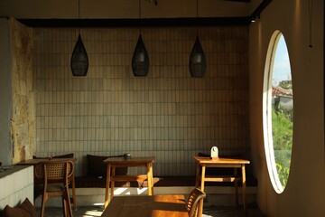 Stylish cafe with wooden furniture and big round window