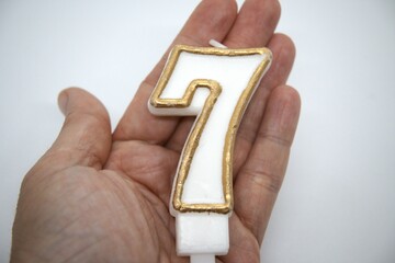 Obraz premium Number 7 birthday candle close up with white background.
