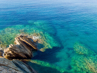 Obraz premium Beautiful sea coast with turquoise sea and rocks in Ios island, Greece.