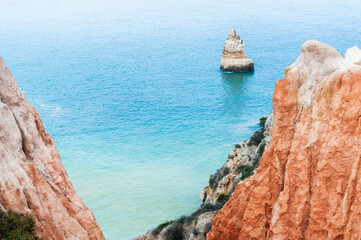 Yellow sandstone rocks on the coast of Atlantic ocean in Algarve, Portugal. Beautiful seascape at foggy morning.
