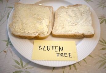 Gluten free subtitle or text with bread and margarine on plate.