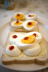 Bread and margarine with sliced egg and red gold sauce on plate.