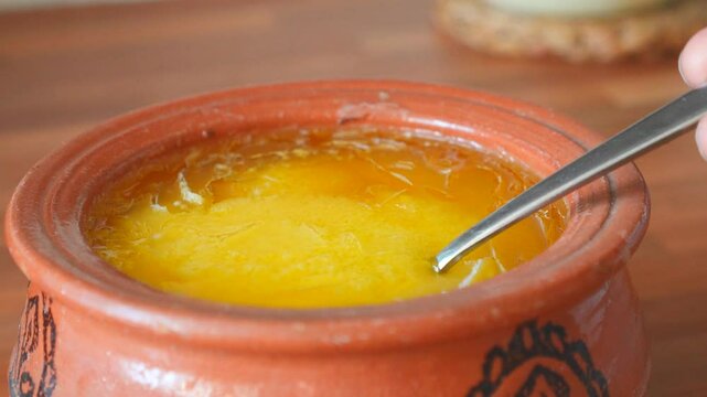Checking Liquid State of Ghee by Repeatedly Pouring into Earthenware Bowl &ndash; Traditional Method

