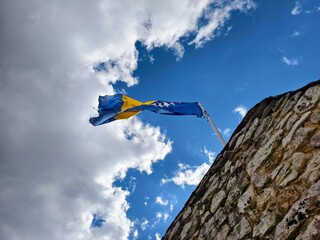 Flag of Bosnia and Herzegovina Waving Against a Blue Sky