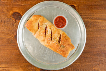 Stromboli with marinara sauce on a tray