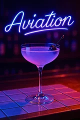 Aviation cocktail in coupe glass with cherry garnish under neon light