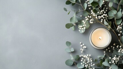 A candle surrounded by eucalyptus