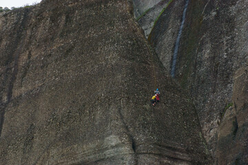 Tourist climbing on rope up at the Meteora rock formations, Kalambaka, Thessaly, Greece