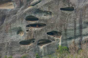 Detail view of eroded caves in side of sandstone rock formations of Meteora once inhabited by hermit monks, Kalambaka, Thessaly, Greece