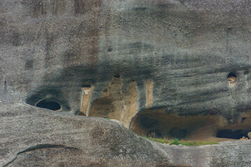 Detail view of eroded caves in side of sandstone rock formations of Meteora once inhabited by hermit monks, Kalambaka, Thessaly, Greece