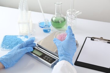 Scientist weighing sample on scales at white table, closeup