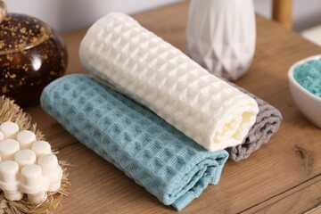 Clean waffle towels and other bath products on wooden dresser, closeup