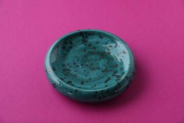 One empty plate on pink background, closeup