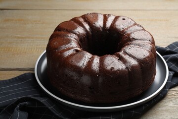 Tasty chocolate bundt cake on wooden table, closeup