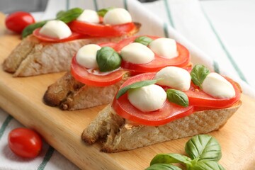 Tasty sandwiches with mozzarella cheese, tomatoes and basil on table, closeup