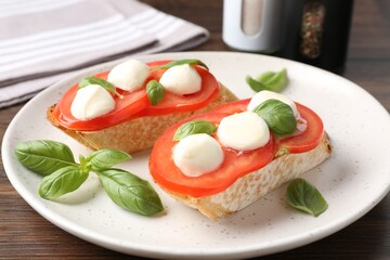 Tasty sandwiches with mozzarella cheese, tomatoes and basil on table, closeup