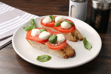 Tasty sandwiches with mozzarella cheese, tomatoes and basil on wooden table, closeup