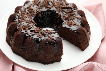 Delicious chocolate bundt cake and napkin on table, closeup