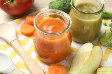 Baby food. Tasty puree in glass jars and ingredients on table, closeup