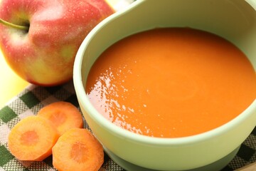 Baby food. Tasty puree in bowl and ingredients on table, closeup