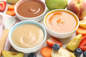 Baby food. Tasty puree in bowls and different ingredients on table, above view