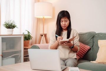 Fototapeta premium Asian Woman Using Laptop Business Finance Calculate Technology Computer Businesswoman Working, Professional Woman Analyzes Her Finances and Investment Strategy While Managing Business Documents