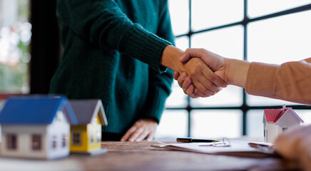 Handshake Real estate brokerage agent Deliver a sample of a model house to the customer, mortgage loan agreement Making lease and buy and sell house And contract home insurance mortgage loan concept	