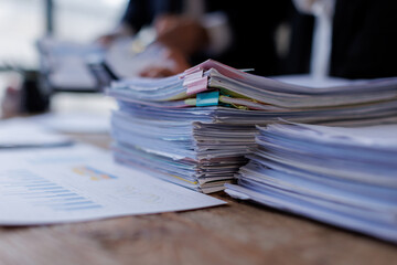 Two busy business professionals man and woman business leaders partners checking document reading financial report talking working together on laptop computer in office at corporate meeting.
