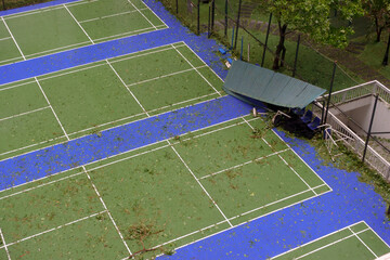 Damaged tennis court in Hanoi after a recent storm with debris scattered across the surface