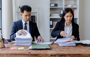 Photo of young Asian business people working and standing near the window in workplace	
