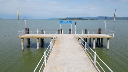 Obraz premium Europe, Italy, Umbria, drone view of Pontile Sant'arcangelo in Trasimeno lake - the landing stage for the ferries that take tourists to the larger and smaller islands - tourist attraction destination