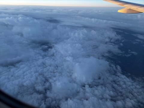 Fototapeta Flying high above clouds seeing land